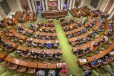 An aerial view of the House Chamber, Representative Urdahl stands in the center of the Chamber and speaks to students, who are sitting in the members' desks.